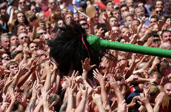 Люди пытаются отведать крин на фольклорном фестивале Дюкасс-Дуду в Монсе, Бельгия. - Sputnik Азербайджан