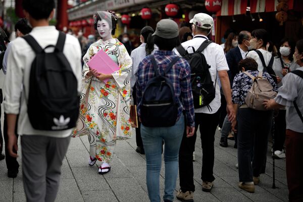 Гейша в традиционном японском кимоно идет по торговой улице в районе Асакуса, Токио, Япония. - Sputnik Азербайджан