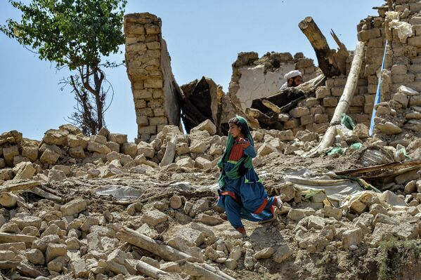 Ребенок среди обломков поврежденных домов после землетрясения в округе Берналь, Афганистан. - Sputnik Азербайджан