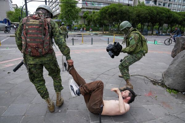 Солдаты задерживают демонстранта во время протестов против правительства в Кито, Эквадор. - Sputnik Азербайджан