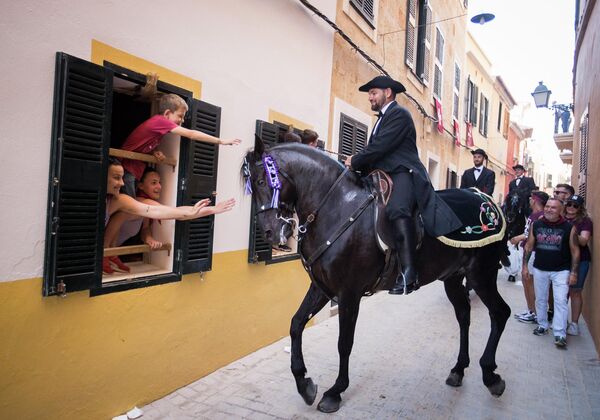 Дети гладят лошадь во время традиционного фестиваля Сан-Хуан в городе Сиудадела, Испания. - Sputnik Азербайджан