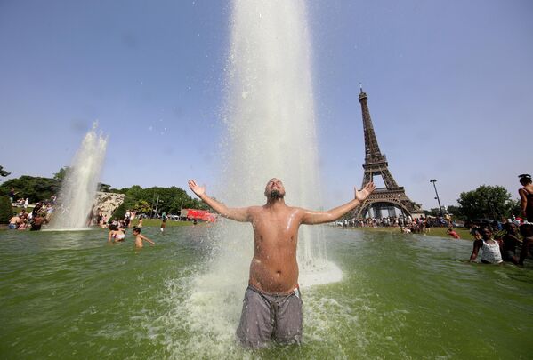 Мужчина остывает в фонтанах Трокадеро напротив Эйфелевой башни в Париже. - Sputnik Азербайджан