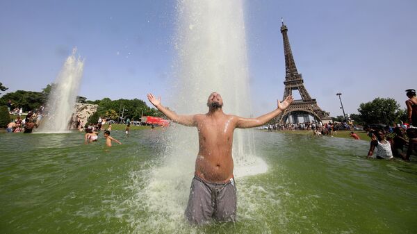 Мужчина остывает в фонтанах Трокадеро напротив Эйфелевой башни в Париже - Sputnik Азербайджан