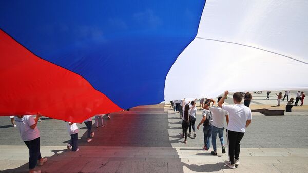 Жители Волгограда несут стометровый флаг России по центру города (флешмоб посвящен Дню России) - Sputnik Azərbaycan