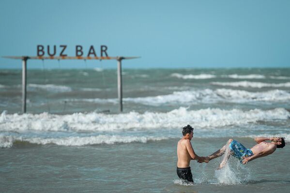 Молодые люди развлекаются на одном из пляжей в Баку. - Sputnik Азербайджан