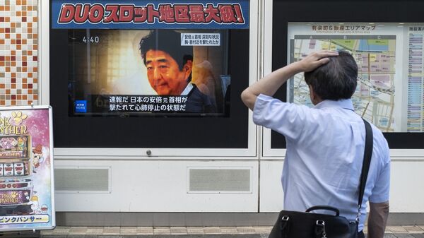 Мужчина смотрит телепередачу, показывающую новости о нападении на бывшего премьер-министра Японии Синдзо Абэ - Sputnik Азербайджан