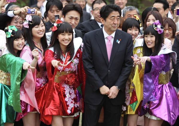 Премьер-министр Японии Синдзо Абэ позирует с участницами женской поп-группы Momoiro Clover Z во время вечеринки в саду Синдзюку-гёэн в Токио. - Sputnik Азербайджан