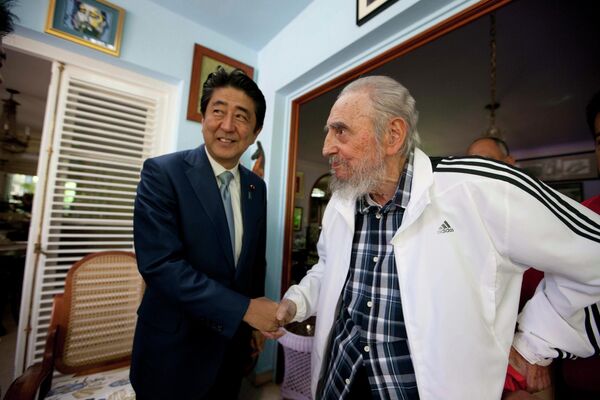 Kubanın keçmiş lideri Fidel Kastro Yaponiyanın baş naziri Şinzo Abe ilə salamlaşır. - Sputnik Azərbaycan