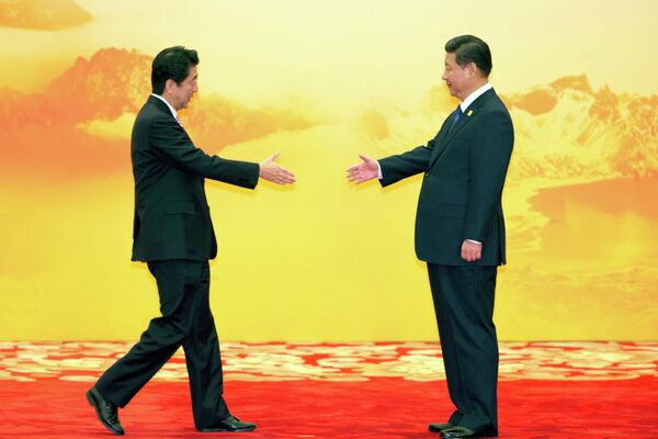 Yaponiyanın baş naziri Şinzo Abe Çin Prezidenti Si Cinpin ilə salamlaşmaq üçün əlini uzadır. - Sputnik Azərbaycan