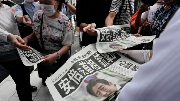 Сотрудник распространяет дополнительные выпуски газеты Yomiuri Shimbun с сообщением покушении на премьер-министра Японии Синдзо Абэ 8 июля 2022 года, Токио - Sputnik Азербайджан