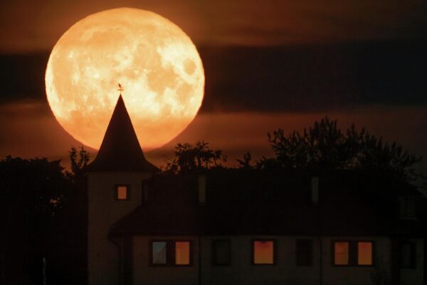 Полная луна восходит над частным домом в деревне Путилово, в 70 км к востоку от Санкт-Петербурга, Россия. - Sputnik Азербайджан