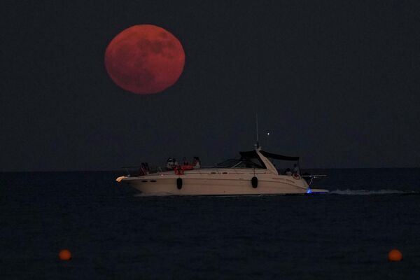 Луна поднимается над Средиземным морем, когда люди на яхте отдыхают в южном прибрежном городе Ларнака, Кипр - Sputnik Азербайджан