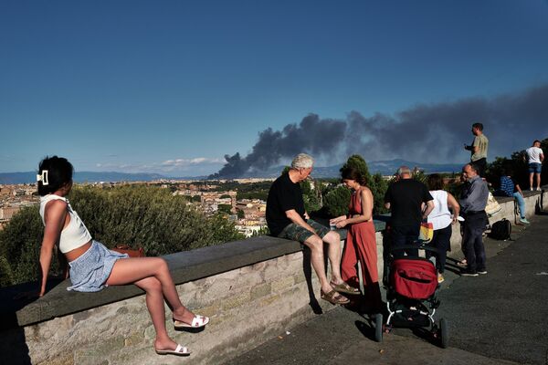 Люди на холме Джаниколо смотрят на дым после пожара в районе Ченточелле, Италия. - Sputnik Азербайджан