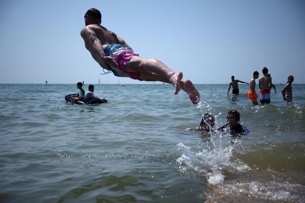 Люди прыгают в море в Брайтоне. - Sputnik Азербайджан