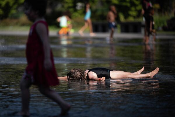 Дети охлаждаются водой из фонтана в Нанте. - Sputnik Азербайджан