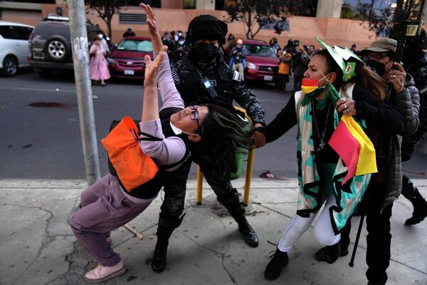 Полицейский пытается помешать антиправительственному демонстранту в Ла Пас, Боливия. - Sputnik Азербайджан