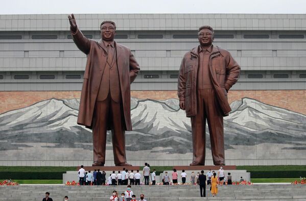 Люди возлагают цветы к статуям северокорейских лидеров Ким Ир Сена и Ким Чен Ира в Пхеньяне по случаю 69-й годовщины окончания Корейской войны. - Sputnik Азербайджан