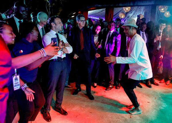 Французский теннисист Янник Ноа танцует рядом с президентом Франции Эммануэлем Макроном во время вечеринки в районе Этуди, Яунде, Камерун. - Sputnik Азербайджан