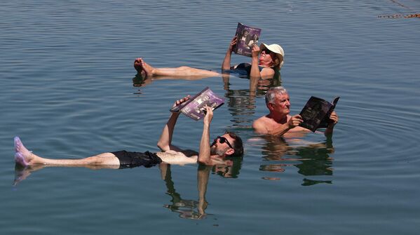 Члены жюри Международного кинофестиваля в Аммане изучают каталог фестиваля, плавая в Мёртвом море. - Sputnik Азербайджан