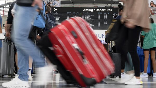 Пассажиры проходят мимо табло с расписанием рейсов в аэропорту - Sputnik Азербайджан