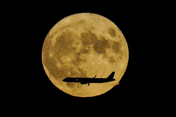 Самолет пролетает перед полной луной в Нью-Йорке. - Sputnik Азербайджан