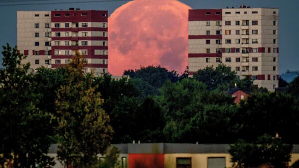 Полная луна садится за жилые дома на окраине Франкфурта, Германия. - Sputnik Азербайджан