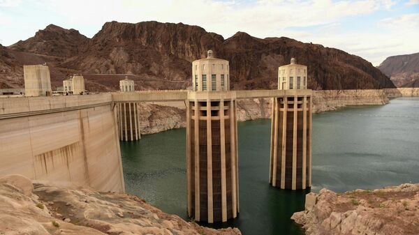 Intake towers for water to enter to generate electricity and provide hydroelectric power stand during low water levels due the western drought on July 19, 2021 at the Hoover Dam on the Colorado River at the Nevada and Arizona state border. - Sputnik Азербайджан