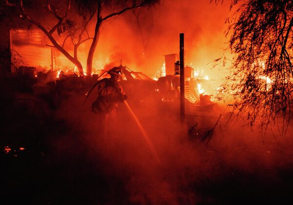 Пожарный тушит лесной пожар в Фэрвью недалеко от Хемета, Калифорния. - Sputnik Азербайджан