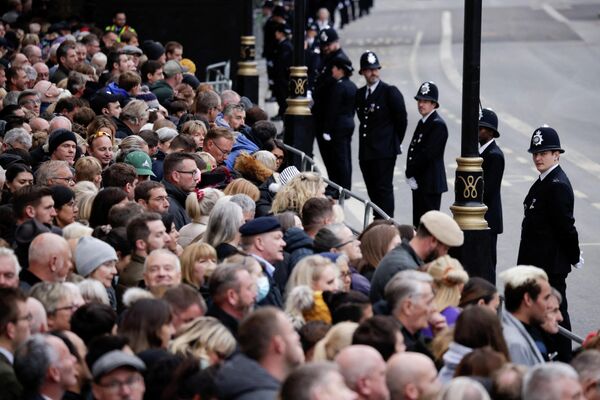 Полицейские стоят на страже, когда скорбящие собираются перед государственными похоронами британской королевы Елизаветы II в Лондоне. - Sputnik Азербайджан
