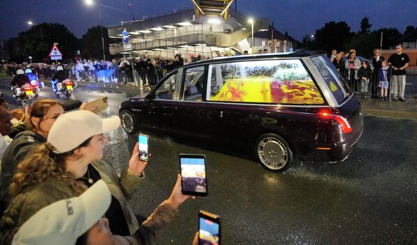 Люди смотрят на государственный катафалк с гробом королевы Елизаветы II. - Sputnik Азербайджан