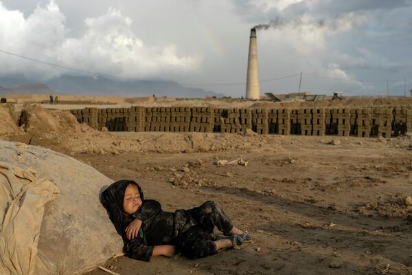 4-летняя афганская девочка спит после работы на кирпичном заводе на окраине Кабула. - Sputnik Азербайджан