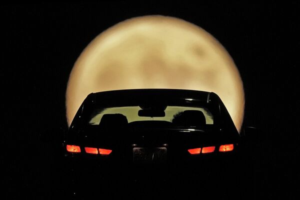 Автомобиль на фоне восходящей охотничьей луны, Шони, штат Канзас. - Sputnik Азербайджан
