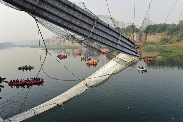 Спасатели ведут поиски пропавших в реке Мачху рядом с обрушившимся мостом в городе Морви, Индия. - Sputnik Азербайджан