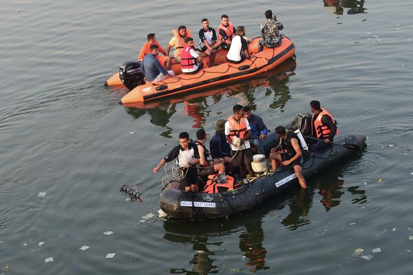 Индийские спасатели проводят поисковые работы после обрушения моста через реку Маччху в городе Морви, Индия. - Sputnik Азербайджан
