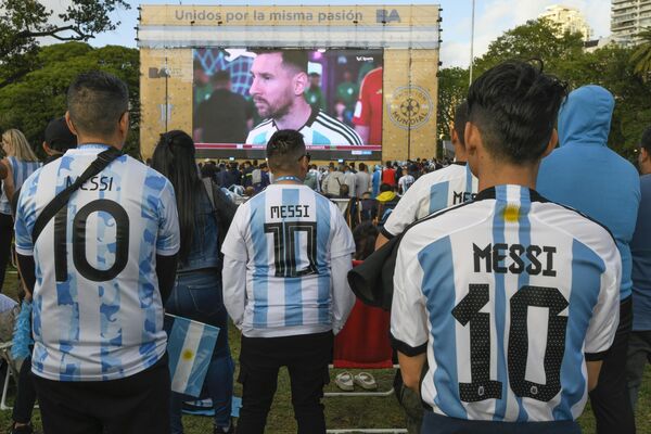 Аргентинские футбольные болельщики в футболках с изображением Лионеля Месси смотрят, как их команда проигрывает Саудовской Аравии в футбольном матче группы C. - Sputnik Азербайджан