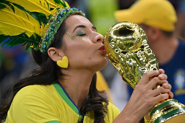 Braziliya ilə Serbiya arasında keçirilən matç zamanı braziliyalı azarkeş &quot;Lusail&quot; stadionunda kubokun maketini öpür. - Sputnik Azərbaycan