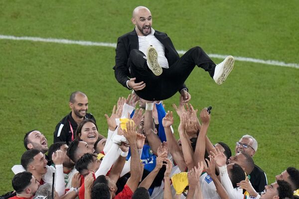 Игроки из Марокко празднуют, подбрасывая в воздух главного тренера Валида Реграги в конце футбольного матча группы F. - Sputnik Азербайджан