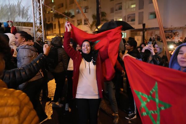 Марокканские болельщики размахивают флагами в Рабате после окончания полуфинального матча чемпионата мира по футболу между Францией и Марокко. - Sputnik Азербайджан
