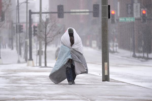 Мужчина с одеялом идет по тротуару в Сент-Луисе. - Sputnik Азербайджан