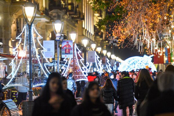 Люди гуляют по украшенной к Новому году центральной улице Баку. - Sputnik Азербайджан