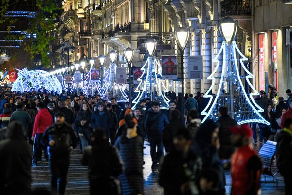 Люди гуляют по украшенной к Новому году центральной улице Баку. - Sputnik Азербайджан