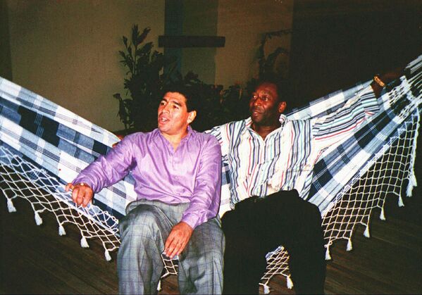 Диего Армандо Марадона (слева) отдыхает в гамаке вместе с  Пеле во время встречи в Рио-де-Жанейро, Бразилия, 13 мая 1995 года. - Sputnik Азербайджан