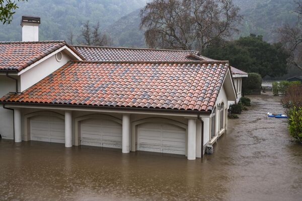 Затопленный в результате наводнения реки Кармель гараж на Пасо-Хондо-роуд в Калифорнии. - Sputnik Азербайджан