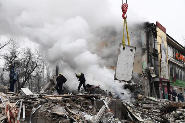 Спасатели на месте разрушенного в результате обстрела со стороны ВСУ торгового центра в Донецке, Россия - Sputnik Азербайджан
