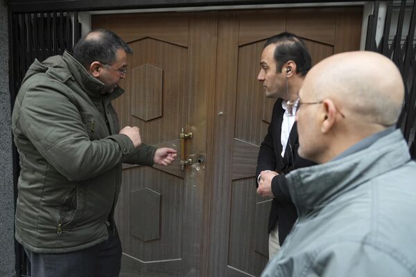 Мужчина показывает на пулевые отверстия, оставшиеся после нападения на посольство Азербайджана в Тегеране. - Sputnik Азербайджан