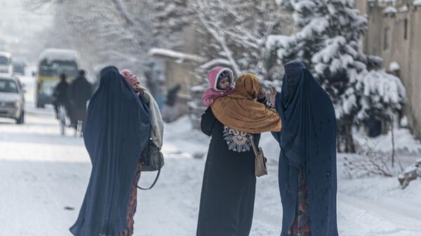 Афганские женщины в парандже несут детей по заснеженной улице Кабула. - Sputnik Азербайджан