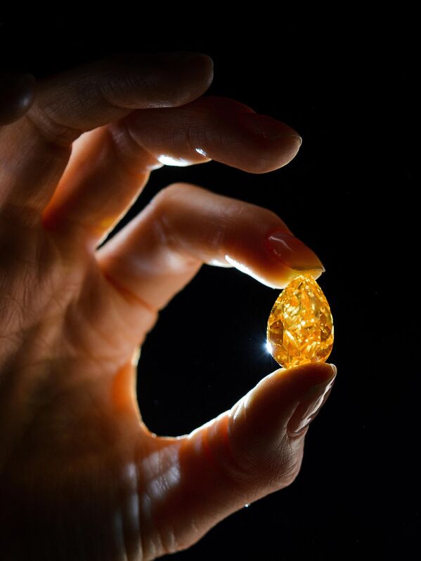 Модель показывает &quot;Апельсин&quot; — ярко-оранжевый бриллиант грушевидной формы весом 14,82 карата в Женеве. - Sputnik Азербайджан