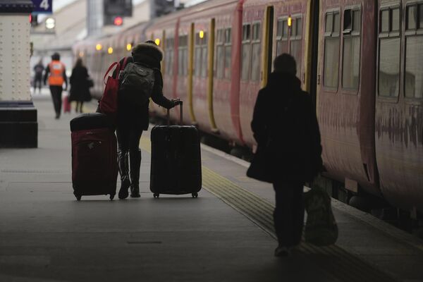 Пассажиры идут по платформе вокзала Ватерлоо в Лондоне. - Sputnik Азербайджан