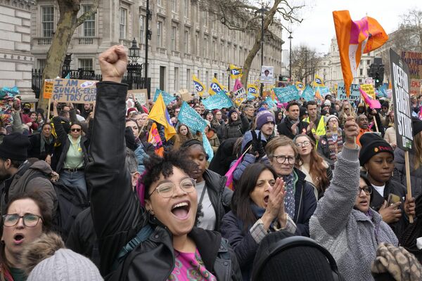 Демонстранты размахивают транспарантами на Даунинг-стрит в Вестминстере в Лондоне. - Sputnik Азербайджан