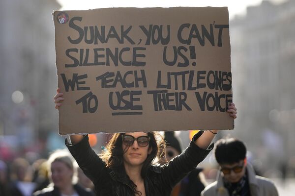 Бастующий учитель показывает плакат во время марша протеста в Лондоне. - Sputnik Азербайджан